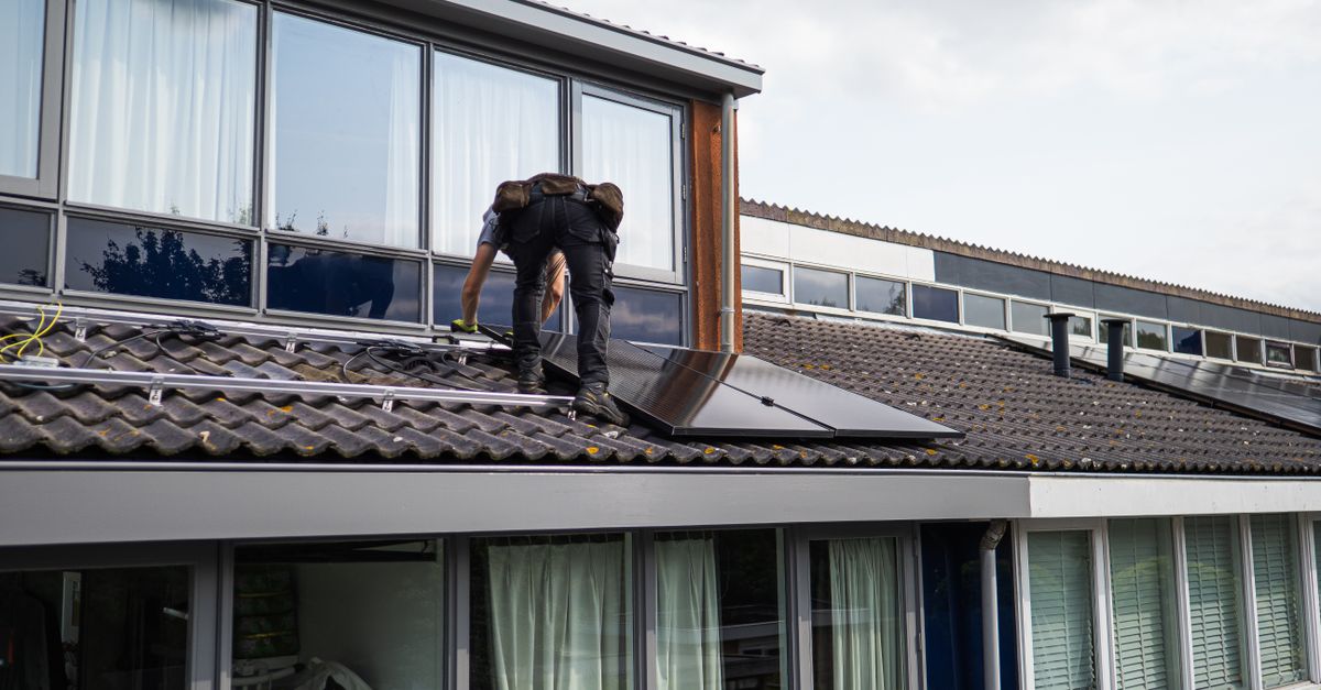 Monteur installiert Solarmodule auf dem Dach eines Einfamilienhauses Fachkraft montiert Photovoltaikmodule auf dem Dach eines Wohngebäudes