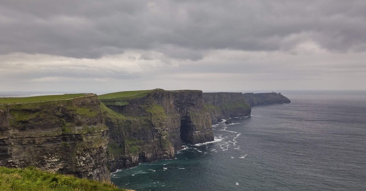 Die Cliffs of Moher an Irlands Westküste mit tief hängenden Wolken über dem Atlantik